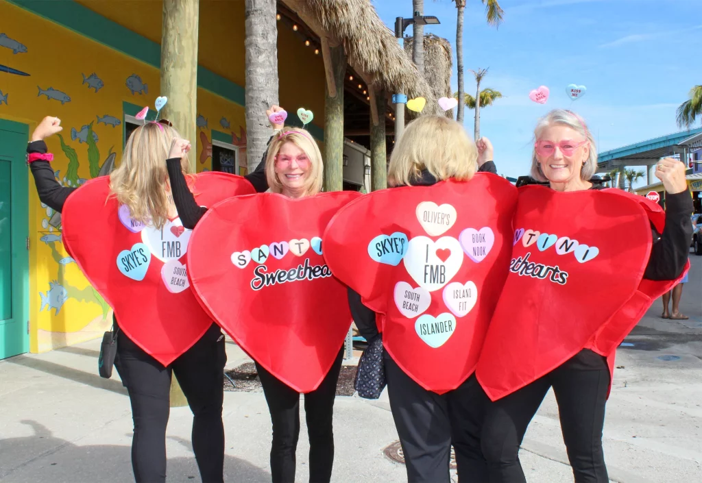 four people wearing red hearts