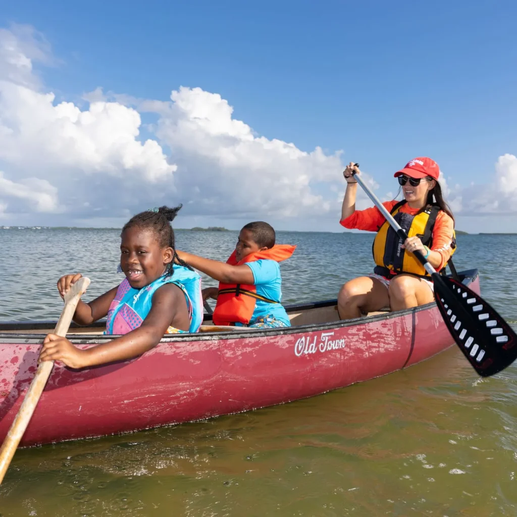 Woman and two young children rowing a boat